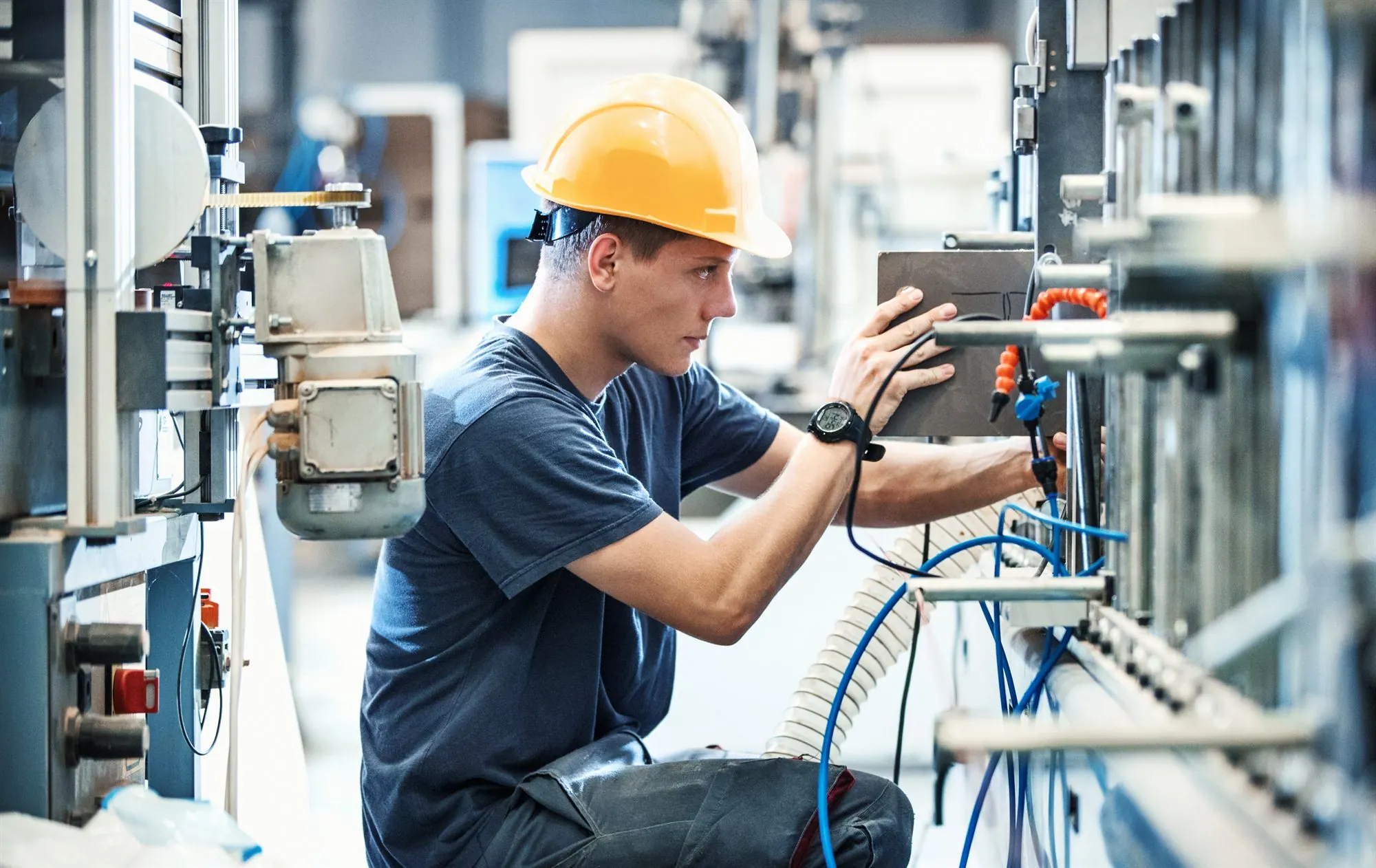 Fachkraft mit Schutzhelm bei der Arbeit an einer Industrieanlage.